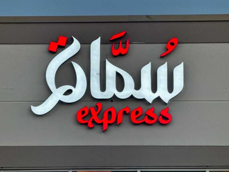 Outdoor backlit channel letter sign in Arabic and English