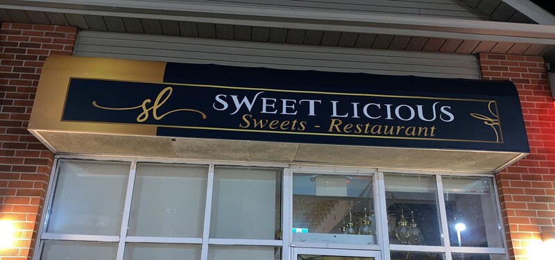 Outdoor illuminated storefront sign  -  the style of commercial sign suited to Elmira's Arthur Street retail strip